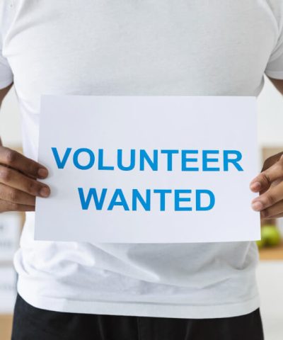 male-volunteer-holding-blank-paper-with-request